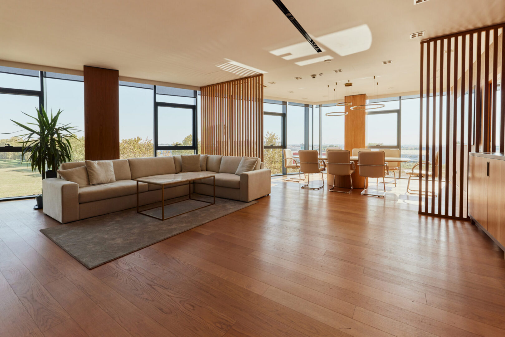 Modern living room with large windows and furniture.