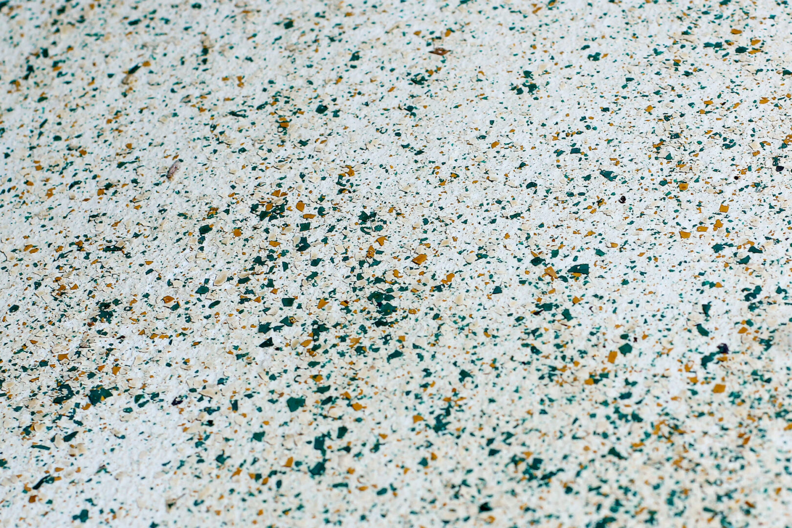 Speckled surface with green and orange spots.