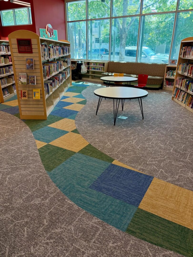 Colorful children's library with bookshelves, tables, and windows